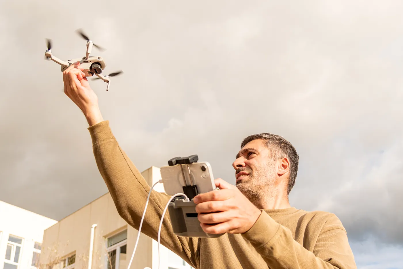 A drone operator launching a drone by hand