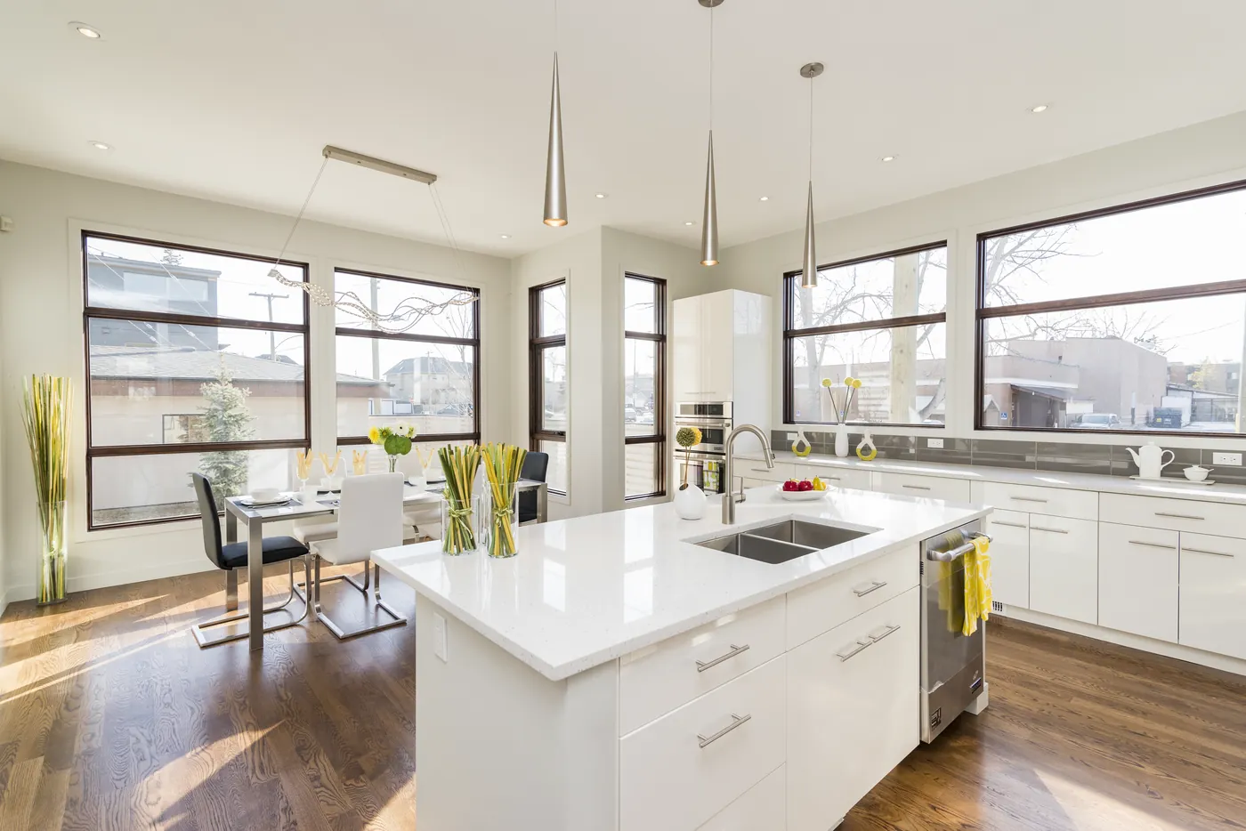 A bright kitchen with a stone island bench and large windows