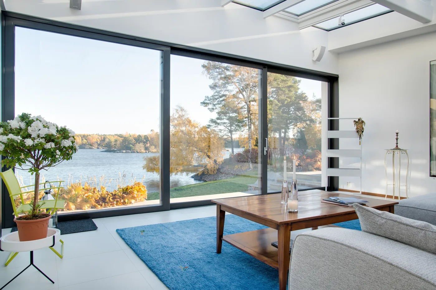A living room with floor-to-ceiling glass looking out over the water